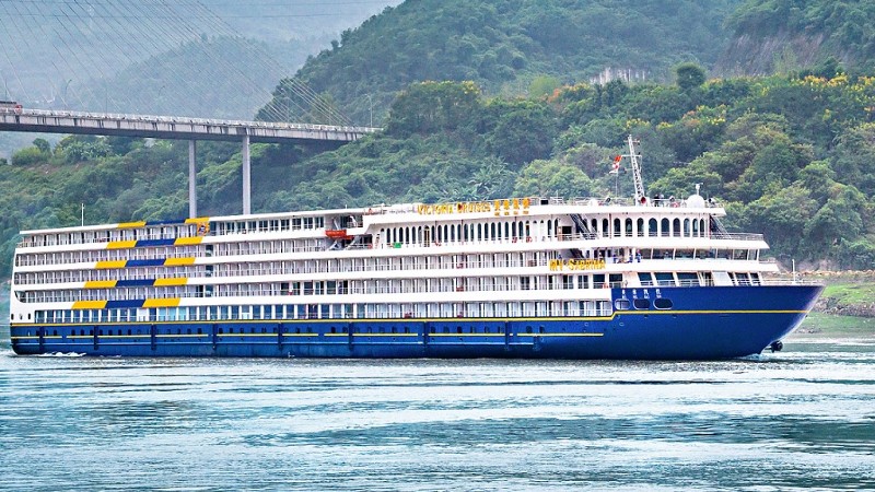 et stort cruiseskip p Yangtze elven i fargene hvitt, bltt og litt gult